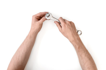 Wall Mural - Close up view of a man's hands working with combination wrench, isolated on white background