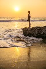 Wall Mural - Beautiful woman on the beach at sunset