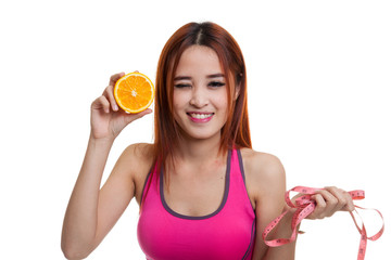 Wall Mural - Asian healthy girl on diet with orange fruit and measuring tape.