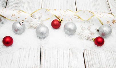 Wall Mural - christmas balls with ribbon on snow