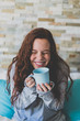 © ADDICTIVE STOCK - Ginger girl laughing with blue cup and lip smeared with milk
