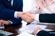 © rogerphoto - Business people shaking hands finishing up a meeting