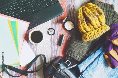 Plakat Płaskie tło moda świeckich / stylowe ubrania damskie, torebki, kosmetyki i laptopa. Jasnoniebieskie dżinsy, brązowa wełniana sweter, żółty kapelusz i szalik w paski. Jesienny lub zimowy bloger mody