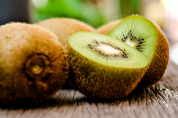 Some fresh Kiwi Fruits (selective focus) on an old wooden table, half of kiwi