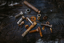 Set Of Rusty Screws, Nuts And Small Tools On A Dark Wooden Backg