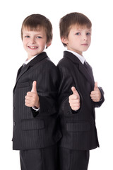 Wall Mural - two cute little boys twins in business suits thumbs up isolated