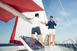 © Drobot Dean - Two young handsome men greeting standing on the yacht