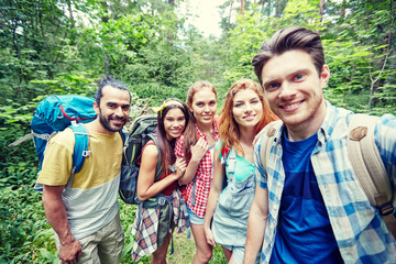 Canvas Print - friends with backpack taking selfie in wood