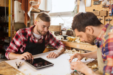 Wall Mural - workmen with tablet pc and blueprint at workshop