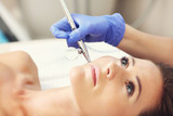 Fototapeta  - Woman having facial treatment in beauty salon