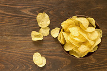Potato Chips In Bowl On A Wooden Background, Top View.