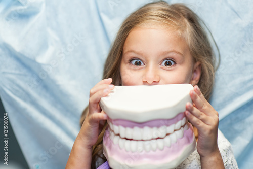 Fotografie, Obraz Dentist curing a child patient in the dental office in a pleasant environment