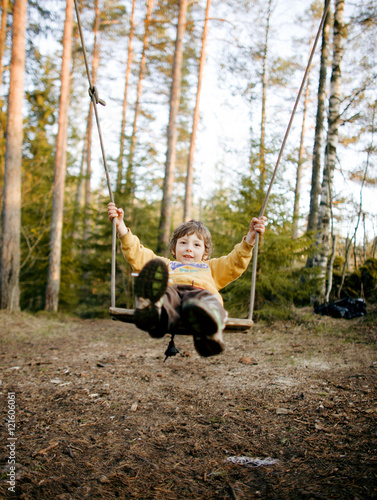 Little Cute Happy Smiling Boy Swinging In Autumn Wood