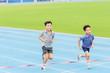 © TinPong - Young Asian boy running on blue track in the stadium