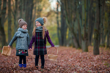 two adorable girls in forest at warm sunny autumn day