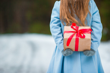 Closeup christmas box gift in kid hands on winter day outdoors