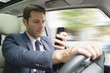 © PhotoAlto - Businessman looking at smartphone in car