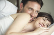 © PhotoAlto - Couple playfully cuddling in bed