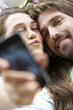 © PhotoAlto - Close-up of young couple taking selfie with a smart phone