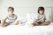 © PhotoAlto - Boys watching tv on bed, portrait