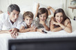 © PhotoAlto - Family watching television together in bedroom
