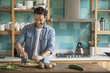 © PhotoAlto - Man chopping up fresh ingredients in kitchen