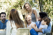 © PhotoAlto - Friends and family enjoying meal together outdoors
