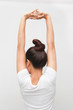 Back view portrait of a young woman stretching hands on white background