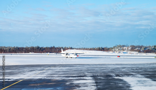 Plakat Samolot pasażerski jedzie na ośnieżonym polu startowym
