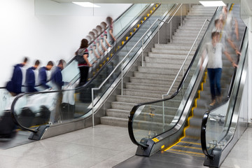 Wall Mural - people on moving escalator motion blur