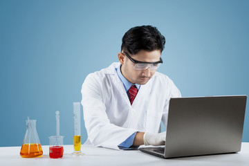 Canvas Print - Scientist with chemical liquid and laptop