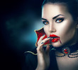 © Subbotina Anna - Halloween portrait. Beauty sexy vampire woman with dripping blood on her mouth
