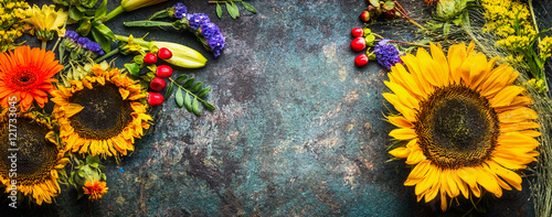 floral-decoration-with-sunflowers-and-fall-flowers-and-leaves-on-dark-vintage-background-top-view-banner-frame