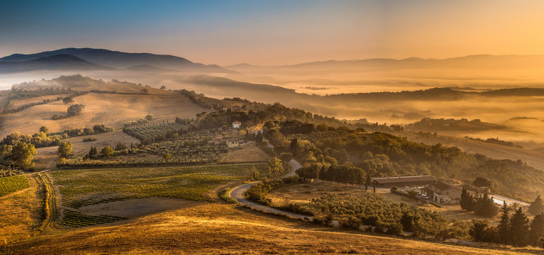 sunrise with fog over tuscan village