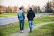 © theartofphoto - Two handsome casual trendy young men, 2 friends, in an urban park walking and chatting together