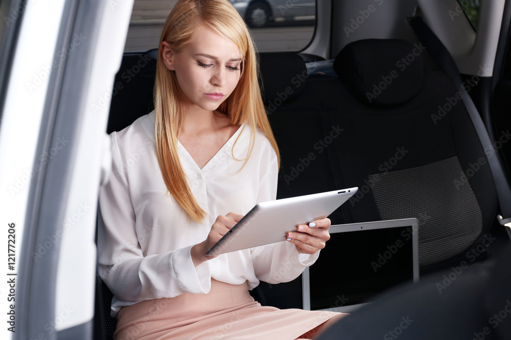 Businesswoman with tablet in a car