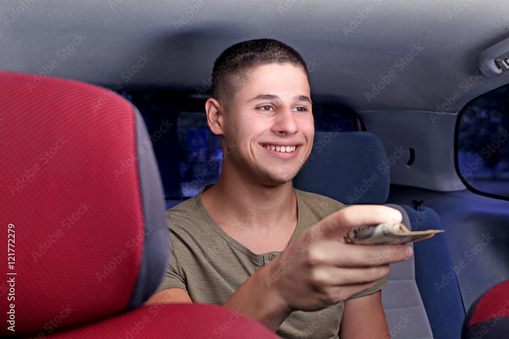 Handsome man paying for taxi