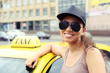 Female taxi driver near car