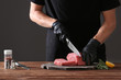 Butcher cutting pork meat on kitchen
