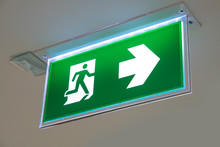 Green Emergency Exit Sign Showing The Way To Escape