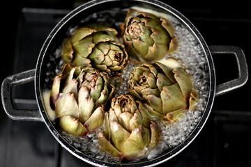 Boiled artichokes in small black pan