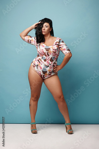 Curvy Woman With Raven Hair In Trendy Combidress Posing Against Blue Background Stock Foto Adobe Stock