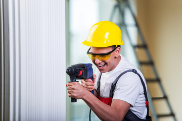 Wall Mural - Man drilling the wall with drill perforator