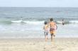 © Claudia - Kids running into the ocean at the beach