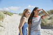 © Westend61 - Two female friends on the beach looking around