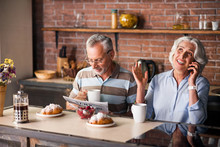 Joyful Senior Citizen Couple Drinking Coffee Together In The Kitchen