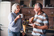 © zinkevych - Happy elderly couple smiling at each other while drinking coffee