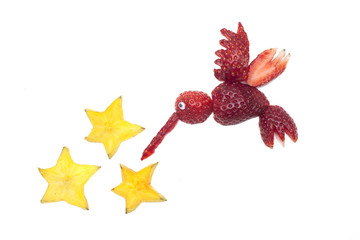 Food art creative concepts. Cute hummingbird made of strawberries with star fruits over a white background.