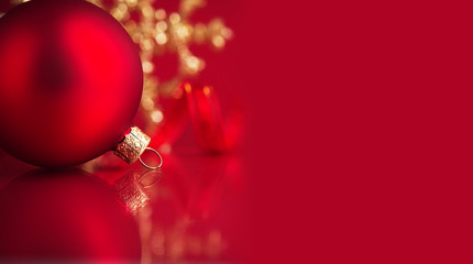 Golden and red christmas ornaments on red background with copy space. Merry christmas card. Winter holidays. Xmas theme.