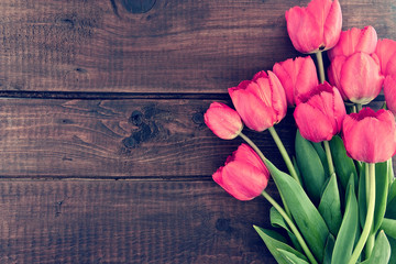 Wall Mural - Bouquet of red tulips on a wooden background. Spring flowers. 